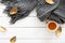 Autumn composition. Feminine desk table with knitted scarf, tea cup, fall leaves on wooden white background. Flat lay, top view.