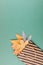 Autumn composition with golden leaves in gift bag on green paper background. Fall mockup with gold maple leaves. Flat lay, top