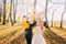 The autumn composition of the happy newlyweds throwing up the yellowed leaves in the park.