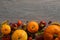 Autumn composition. Orange pumpkins, autumnal fruits and nuts on dark wooden table. Harvest or Thanksgiving background. Flat lay,