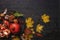 Autumn composition. Pomegranate with nuts, spices and dry leaves on a dark wooden table. Top view. Copy space