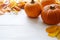 Autumn composition. Pumpkins, fall leaves on white table. Halloween concept.