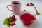 Autumn composition with viburnum jam, viburnum branches and leaves, white linen towel, pink cup, and wooden spoon. Concept of