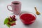 Autumn composition with viburnum jam, viburnum branches and leaves, white linen towel, pink cup, and wooden spoon. Concept of