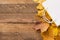 Autumn composition. white bag with autumn yellow dried leaves on wooden whute background. Flat lay, top view, copy space