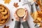 Autumn concept. First person top view photo of girl`s hands in sweater holding cup of coffee wicker tray with cookies scarf falle