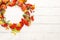 Autumn concept with pumpkins, flowers, autumn leaves and  rowan berries on a white rustic background. Festive autumn decor, flat