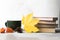 Autumn concept stack of books, coffe cup and maple leaves