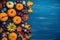 Autumn copyspace with white and orange mini pumpkins, red berries and wedge leaves, set against a striking blue wooden background