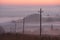 Autumn country landscape. Power line in fog in sunrise