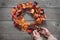 Autumn crafts,  decor on a wooden table, the designer makes a wreath of fallen leaves, fruits and berries, interior decoration in