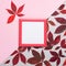 Autumn creative composition. Red leaves, empty pink frame, wild grape berries on gray paper background