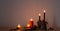 autumn dark decor with candles on wooden shelf on background wall