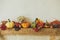 Autumn decor on fireplace in rustic room. Stylish pumpkins, flowers, berries, nuts on rustic wood on stylish fireplace. Harvest at