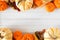 Autumn double border of pumpkins and fall decor on a white wood background