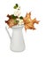 Autumn dry maple leavesand snowberries in a white jug