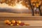 Autumn Elegance: Tabletop Product Display Amidst a Golden Sunset Sky and Falling Leaves.