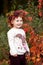 Autumn emotional portrait of little  girl. Pretty little girl with red grape leaves in autumn park. Autumn activities for children