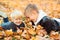 Autumn family weekend. Happy family on a walk in autumn. Two boys playing in autumn leaves