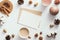 Autumn feminine desk table with romantic letter, coffee cup, candles, pine cones, cotton, cinnamon sticks on white background.