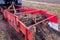 Autumn field with onion crop grown by drip irrigation technology. A tractor-mounted trailed root harvester working. The bulbs are