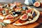 Autumn flat bread with figs, caramelized onions, blue cheese and rosemary, close up on a wood board