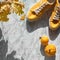 Autumn flat lay with yellow sneakers, autumn  leaves and decorative pumpkins with shadows, square composition