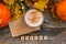 Autumn flatlay composition with letter, craft envelope, coffee latter cup mug, wooden letters text Autumn, leaves