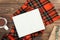 Autumn flatlay composition. Top view on book with empty pages, red knitted scarf, cup of tea, gift box on wooden background.