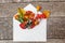 Autumn floral composition. Plants viburnum rowan berries dogrose fresh flowers colorful leaves in mail envelope on wooden