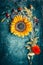 Autumn flowers arrangements with sunflowers, leaves and canina berries on rustic blue background