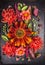 Autumn flowers composition with sunflower, dahlias and herbs on dark table