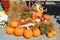 Autumn flowers and pumpkins decoration on straw-bale beside wagon wheel on the ground