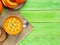 Autumn food. Pumpkin puree soup, bright slime green wooden table, top view, copy space