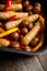 Autumn foodie: grilled sausages with pumpkin slices, potato and bell pepper on the wooden background