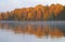 Autumn forest on the lake at sunrise.