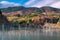 Autumn forest landscape with mountains, blue sky and lake death