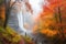 autumn forest with misty waterfall and person enjoying nature escape
