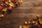 Autumn frame made of dried fall leaves, apples, red berries, walnuts on wooden table. Thanksgiving, Halloween, Autumn Harvest