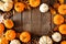 Autumn frame of pumpkins and natural fall decor on a rustic dark wood background