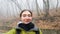 Autumn frame: a teenage traveler takes a selfie against a background of bald trees. A woman travels with a backpack