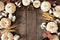Autumn frame of white pumpkins with brown fall decor over a rustic dark wood background