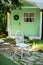 Autumn front porch home. Exterior wooden porch home with garden furniture. Interior summer patio. White wooden chair. Cozy terrace