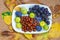 Autumn fruits and berries on a white plate grapes, figs, plums, jyjybe