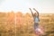 Autumn Girl enjoying nature on the field. Beauty Girl Outdoors raising hands in sunlight rays. Beautiful Teenage Model girl