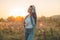 Autumn Girl enjoying nature on the field. Beauty Girl Outdoors raising hands in sunlight rays. Beautiful Teenage Model girl