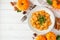 Autumn gnocchi with pumpkin cream sauce, top view table scene over white wood with copy space