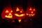 Autumn and halloween decoration with pumpkins carved in the candlelight in the dark