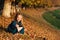 Autumn happy baby girl playing with fallen golden leaves. Happy carefree childhood. Little girl in a blue coat walking at autumn p