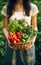 Autumn harvest concept, Unrecognizable hands young woman gardener with harvested vegetables in basket in backyard